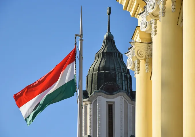 Le drapeau national hongrois à côté de l'église dans la ville de Debrecen ©iStock/majorosl